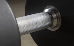 XMARK round commercial urethane dumbbells with black handles, available in 5-50 lb and 5-75 lb sets for strength training.
