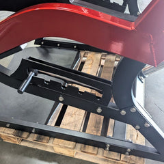 Plate loaded Muscle D Fitness Pro Strength Power Hack Squat machine with padded seat and weight plates in a commercial gym setting.