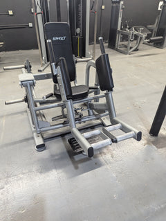 Plate loaded Sweet Glute and Outer Thigh machine in black, red, and silver from Muscle D Fitness, showing padded seat and thigh supports.
