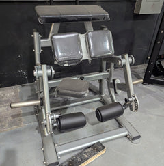 Muscle D Fitness Pro Strength adjustable kneeling leg curl machine in silver, plate-loaded for targeted hamstring workouts.