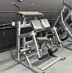 Muscle D Fitness Pro Strength adjustable kneeling leg curl machine in silver, plate loaded for targeting hamstring muscles.