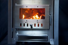 North Shore Sauna XL wood stove inside a portable sauna tent, showcasing a compact, wood-burning heating system for outdoor relaxation.