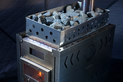 North Shore Sauna XL wood stove inside a portable sauna tent, showcasing the compact design and heating element.