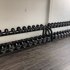 Muscle D Fitness Sweet Dumbbell Set 5-100 lb with adjustable weights and rack, displayed on a clean gym floor.