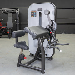 Muscle D Fitness Vogue Biceps Triceps Combo selectorized machine with padded seats and handles for arm muscle workouts.