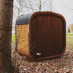Outdoor ThermoWood sauna by Patio Elegance featuring a wooden exterior and glass door, set in a backyard relaxation area.