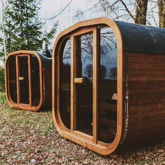 Exterior view of Patio Elegance Mande MW20 Outdoor ThermoWood sauna in a backyard setting, showcasing its wooden construction and door.