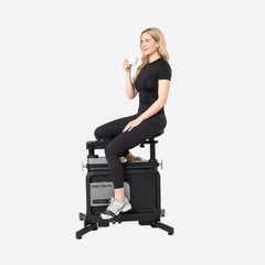 WalkingPad foldable exercise bike under desk for fitness, woman sitting and resting while using the compact walking bike.